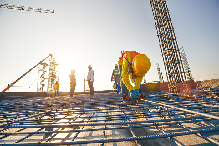 Construction worker carrying a wood beam