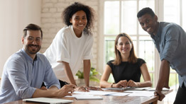 Five multi-ethnic business people gather in boardroom