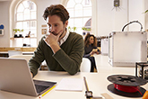 Man in a design studio working on a laptop