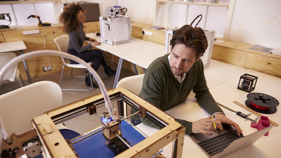 Male and female workers work at prototyping in a workshop.